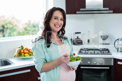 Pregnant woman eating salad