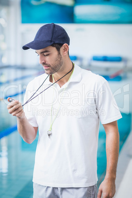 Handsome trainer looking at stopwatch