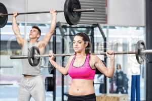 Fit couple lifting barbell