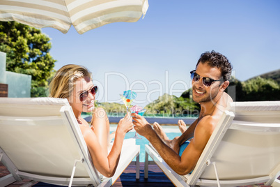 Happy couple on deck chair holding cocktails