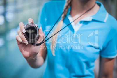 Fit trainer showing stopwatch at the camera