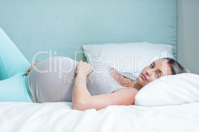 Pregnant woman lying on her bed