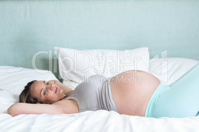 Pregnant woman lying on her bead