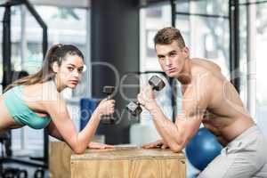 Fit couple lifting dumbbells