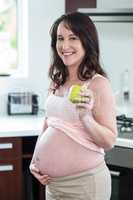 Pregnant woman holding apple