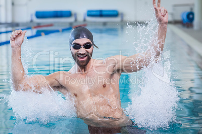 Smiling man triumphing with raised arms