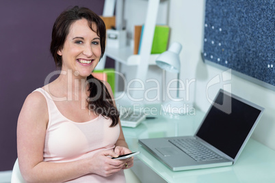 Pregnant woman on her smartphone Pregnant woman on her smartphone