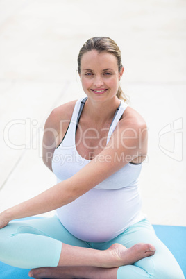 Pregnant woman stretching on mat