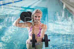 Attractive woman lifting dumbbells