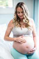 Pregnant woman applying cream on her belly