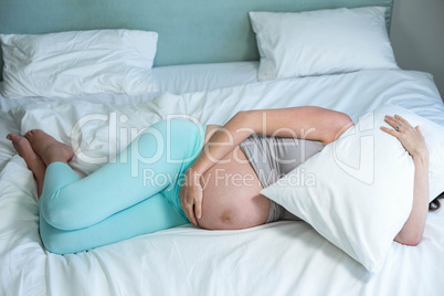 Pregnant woman lying on her bed