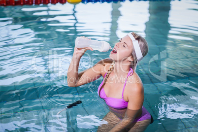 Fit woman doing underwater bike and drinking water