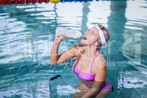Fit woman doing underwater bike and drinking water