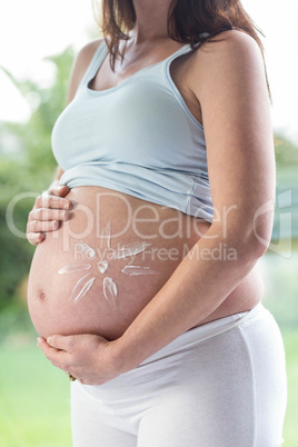 Pregnant woman applying cream on her belly