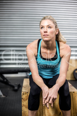 Fit woman sitting on wooden box