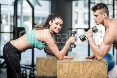 Fit couple lifting dumbbells