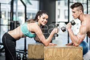 Fit couple lifting dumbbells