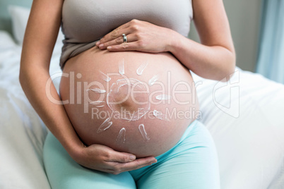 Pregnant woman applying cream on her belly