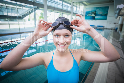 Pretty woman putting on swimming goggles