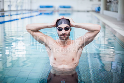 Focused man wearing swim cap and goggles