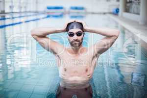 Focused man wearing swim cap and goggles