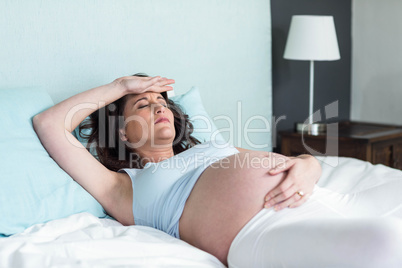 Pregnant woman resting on her bed