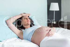 Pregnant woman resting on her bed