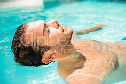 Peaceful man floating in the pool