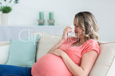 Pregnant woman blowing her nose