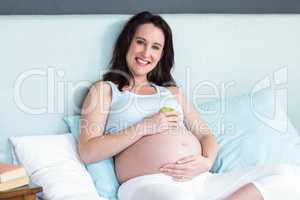 Pregnant woman holding an apple on her belly