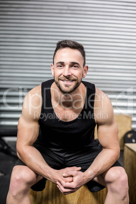 Fit man sitting on wooden box