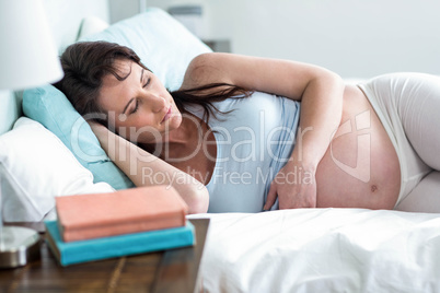 Pregnant woman resting on her bed