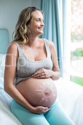 Pregnant woman applying cream on her belly