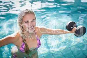 Attractive woman lifting dumbbells