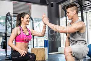 Athletic man and trainer woman giving a high five