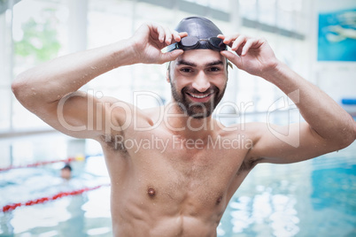 Fit man wearing swim cap and goggles