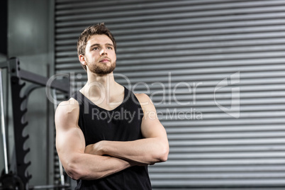 Thoughtful fit man with crossed arms