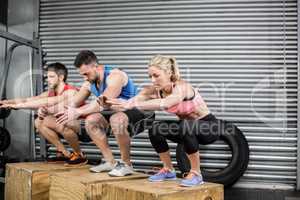 Fit people doing exercises with box
