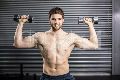 Front view of smiling man lifting weight