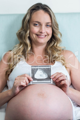 Pregnant woman showing an ultrasound picture