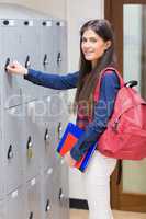 Smiling student opening locker