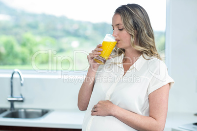 Pregnant woman drinking a glass of orange juice