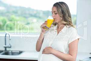 Pregnant woman drinking a glass of orange juice