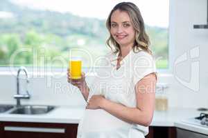 Pregnant woman drinking a glass of orange juice