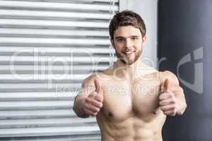 Shirtless fit man with thumbs up