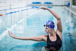 Fit woman stretching her arms in the water