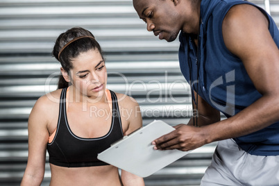 Athletic trainer explaining workout plan to woman