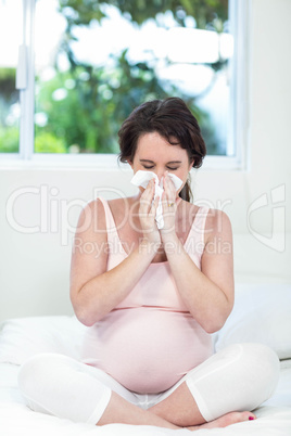 Pregnant woman sitting on bed