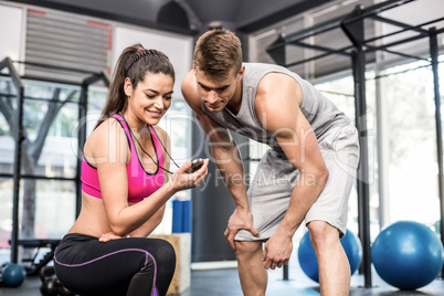 Athletic man checking time with trainer woman