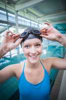 Pretty woman putting on swimming goggles